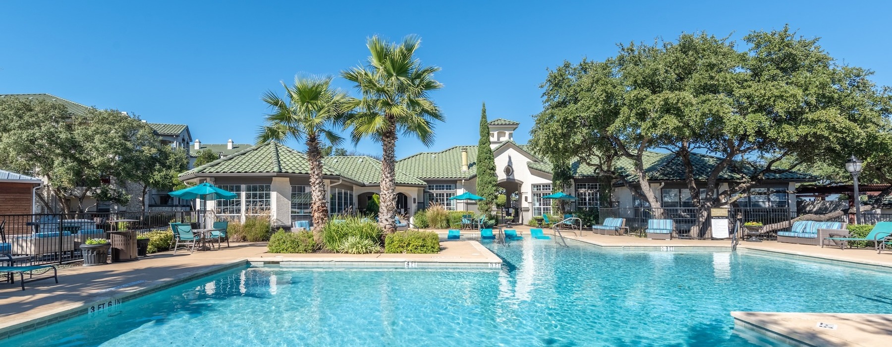 a pool with trees and buildings in the background