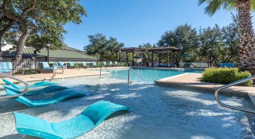a pool with lounge chairs